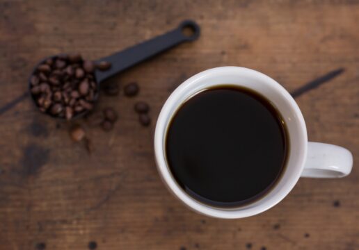 Black coffee beside coffee beans