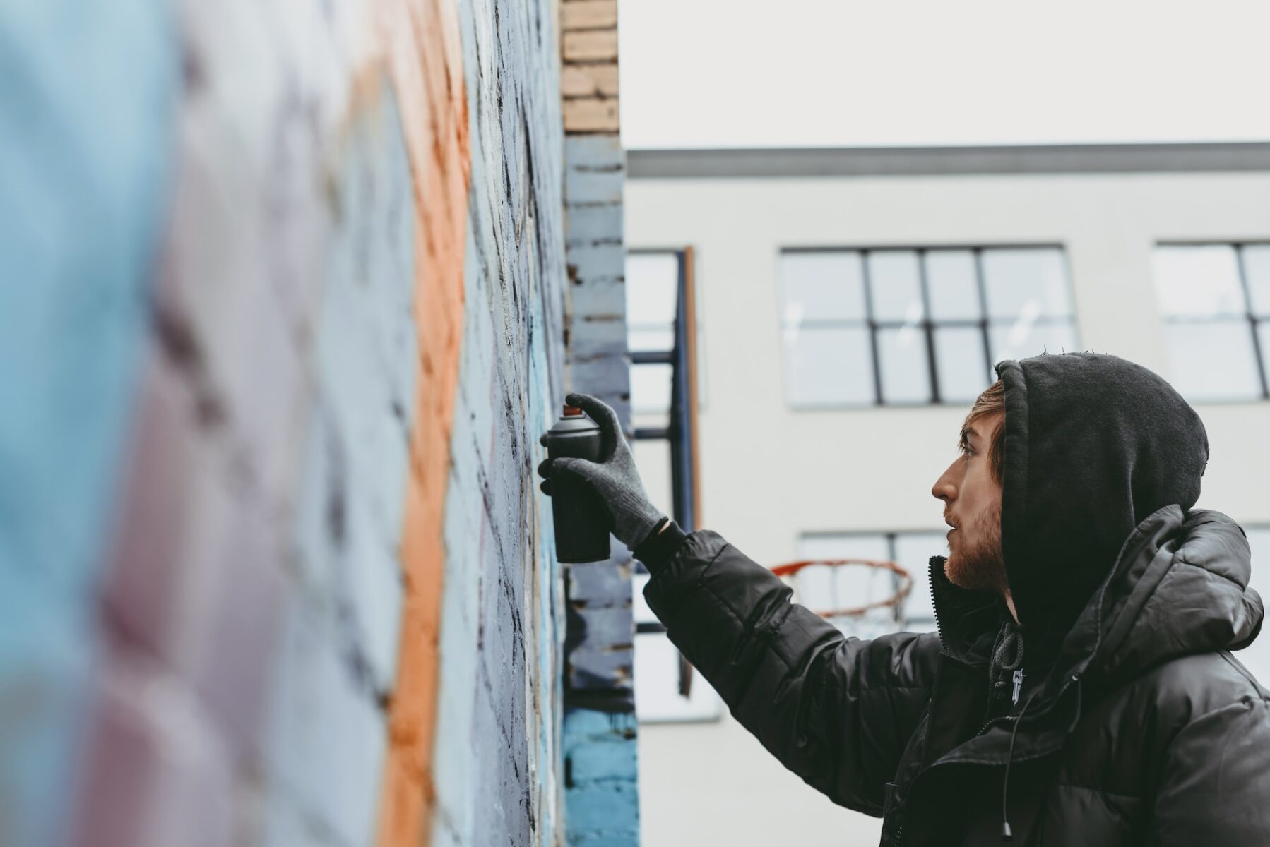 man painting colorful graffiti on wall