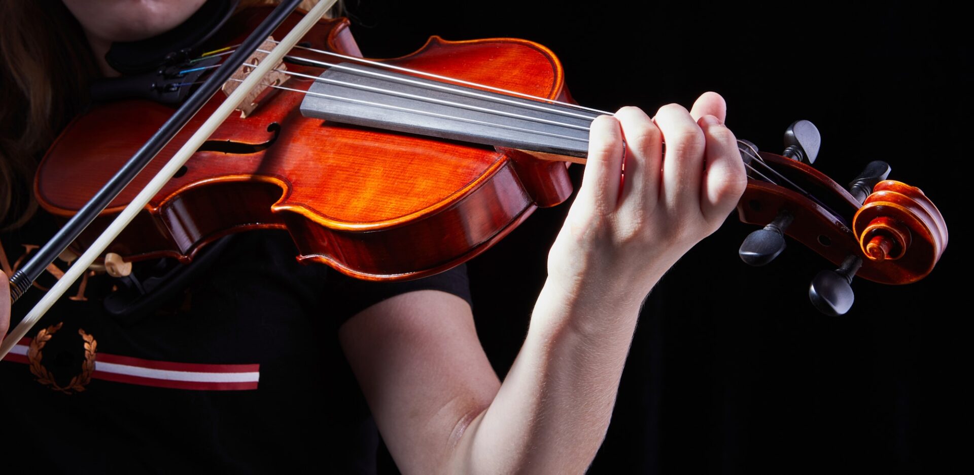 Violin classic musical instrument. Classic player hands on a black background.